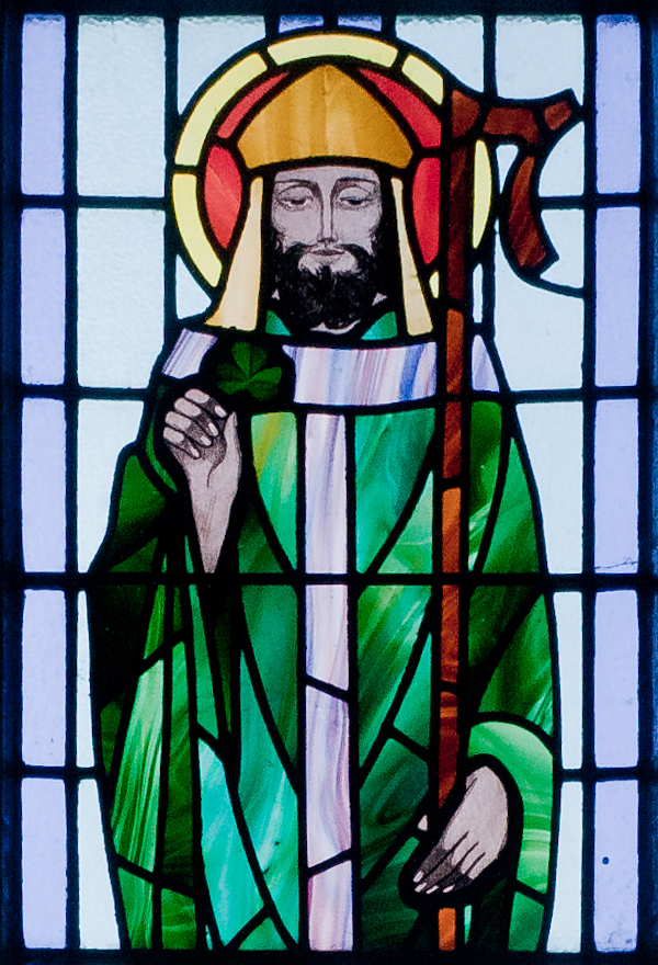 St. Patrick depicted with shamrock in detail of stained glass window in St. Benin's Church, Wicklow, Ireland