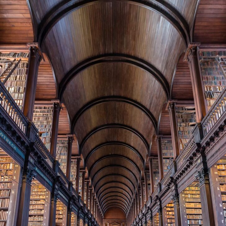 Book of Kells visit: the Long Room of Trinity College Dublin's Old Library, a long barrel-vaulted wooden hall lined on two levels with tall bookcases full of old books