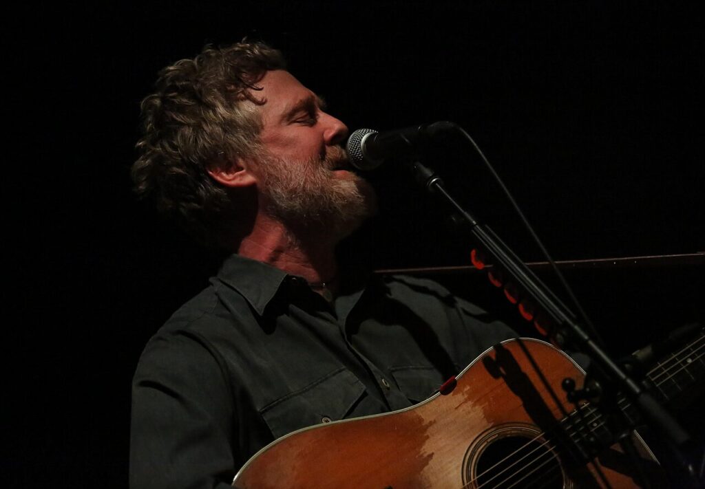 Glen Hansard singing with his guitar on stage
