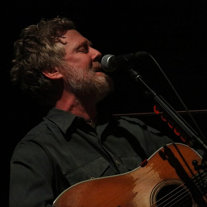 Glen Hansard singing with his guitar on stage