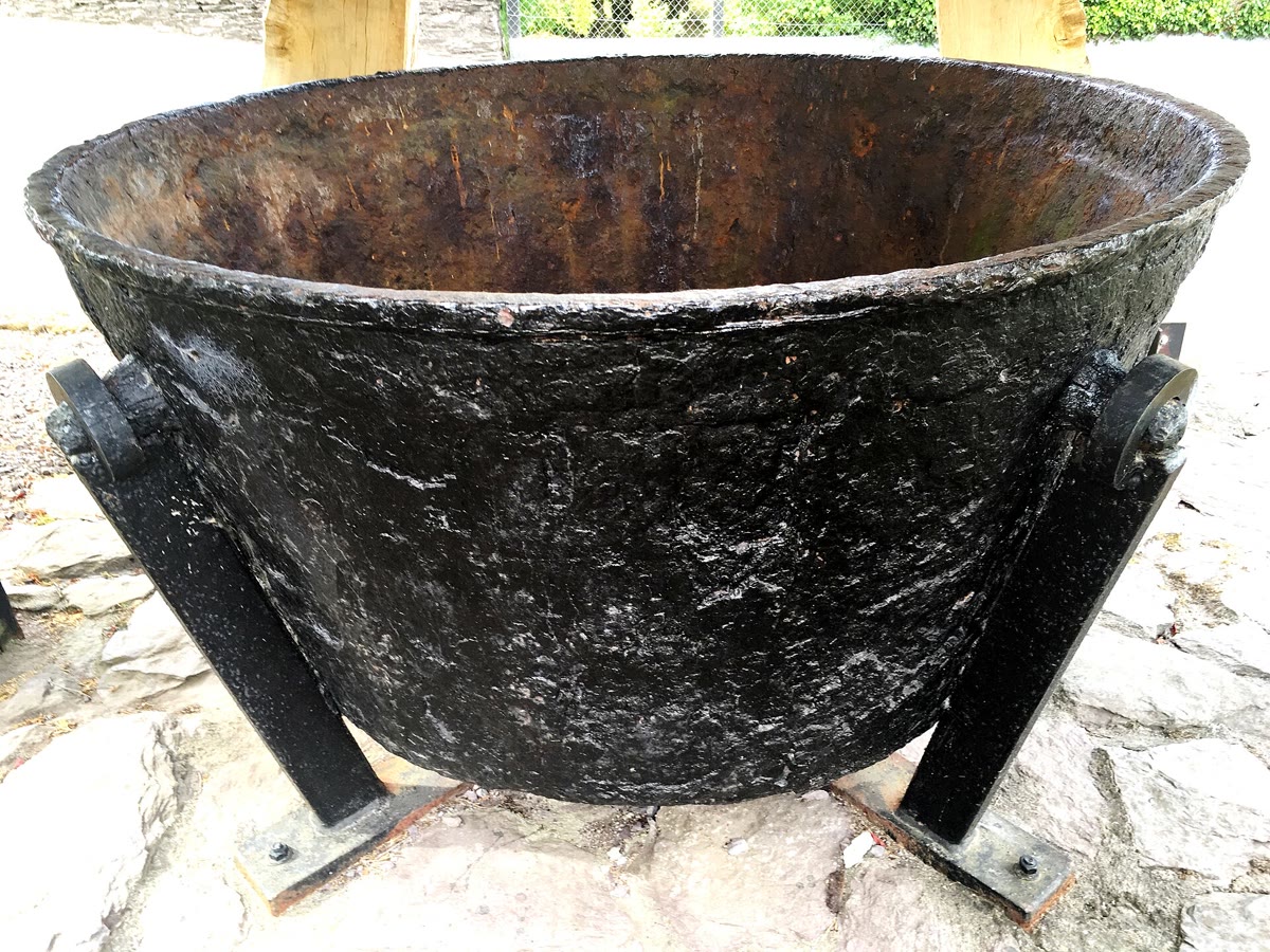 Large black cast-iron cauldron on an iron stand, a soup pot that local historians say fed hungry families in Ballingeary, County Cork, during the Famine