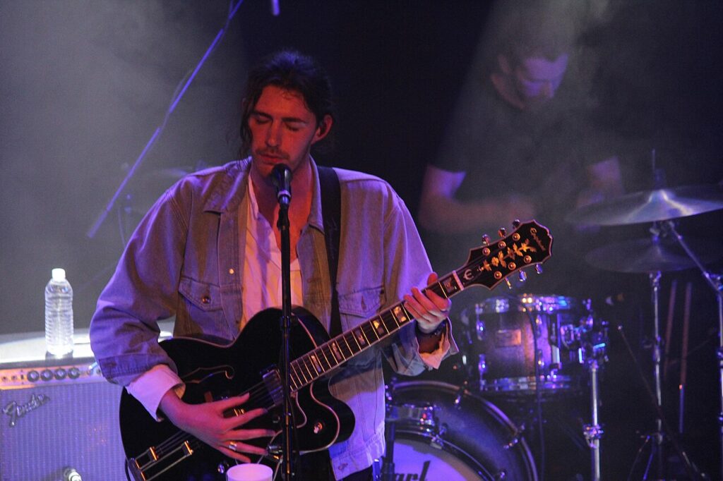 Hozier performing on stage with guitar