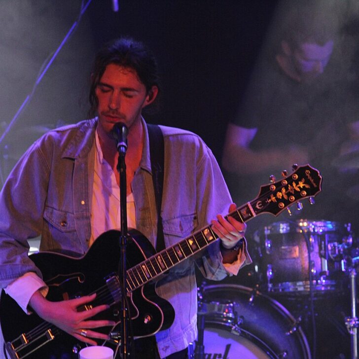Hozier performing on stage with guitar