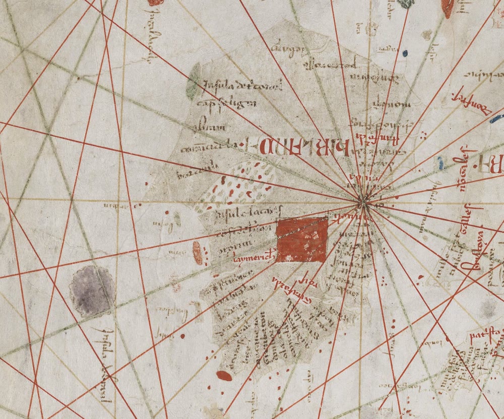 Detail of a 1339 parchment sea chart: Ireland, crossed by red and green compass lines and marked with a red square, with a round lilac island labelled in Latin out to sea at lower left