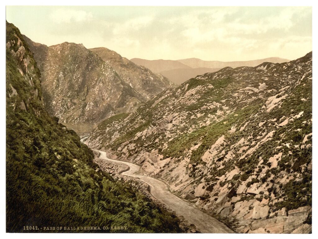 Hand-coloured 1890s photochrom of a narrow road winding up through the rocky Pass of Ballaghbeama in Co. Kerry