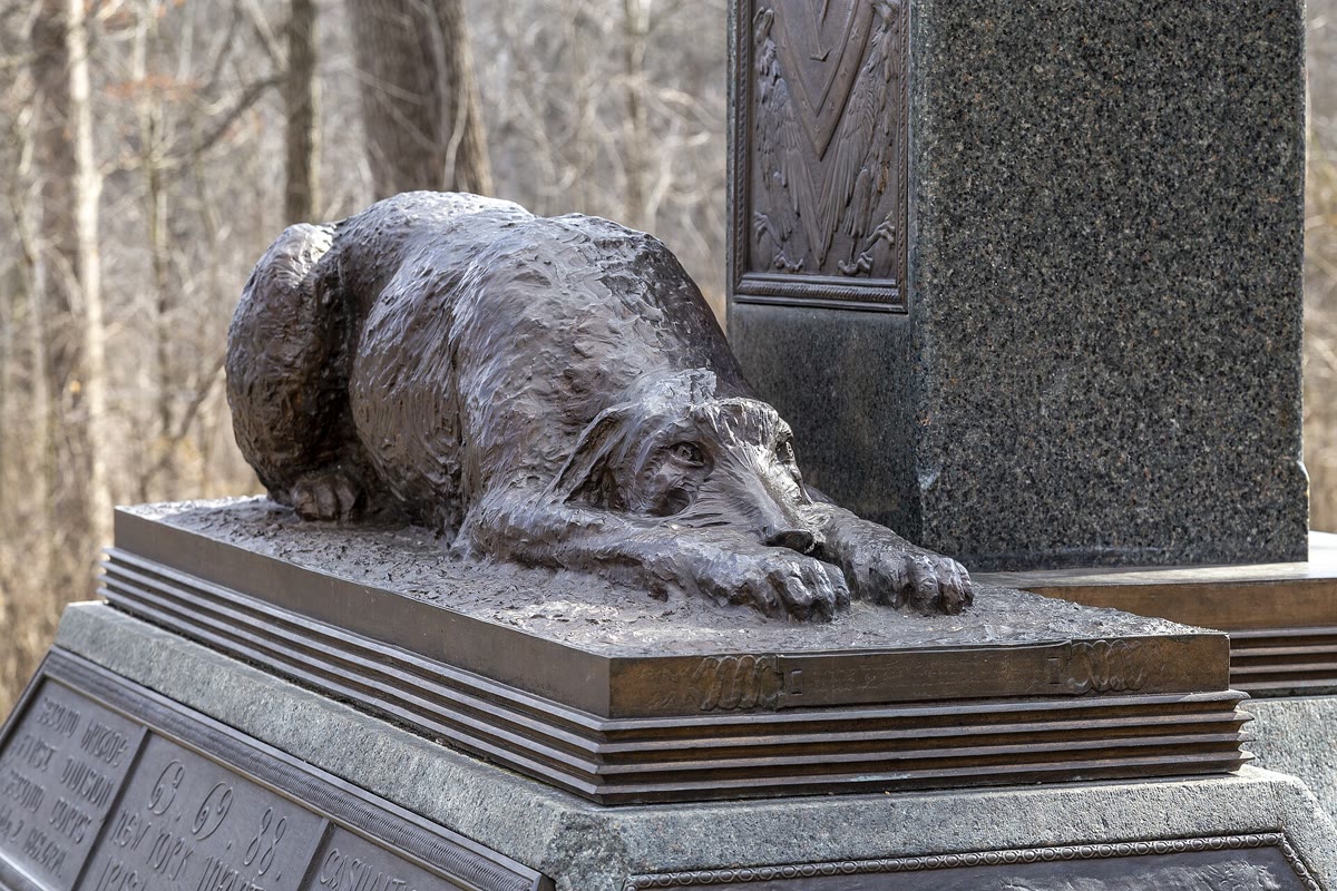 Bronze Irish wolfhound lying with its head on its paws at the foot of the Irish Brigade's Celtic cross monument at Gettysburg