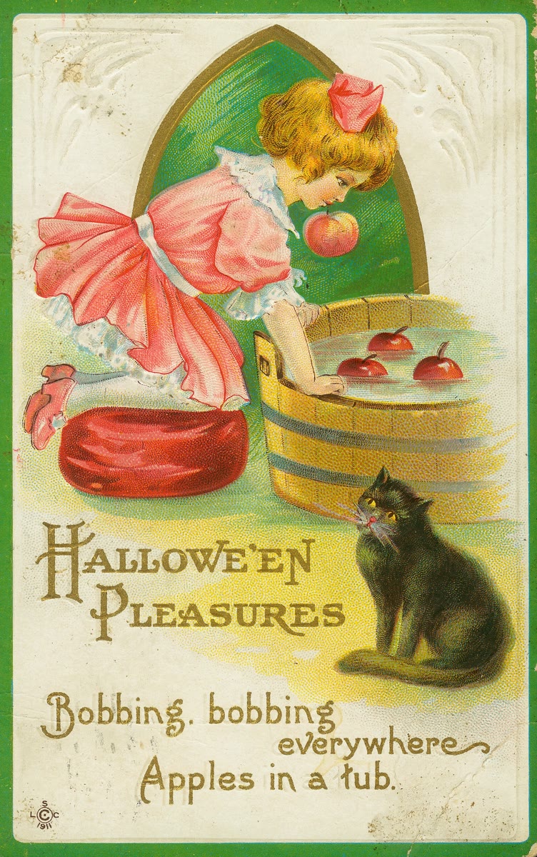 Vintage 1911 Halloween postcard of a girl in a pink dress leaning over a wooden tub to bite a floating apple, with a black cat sitting beside the tub