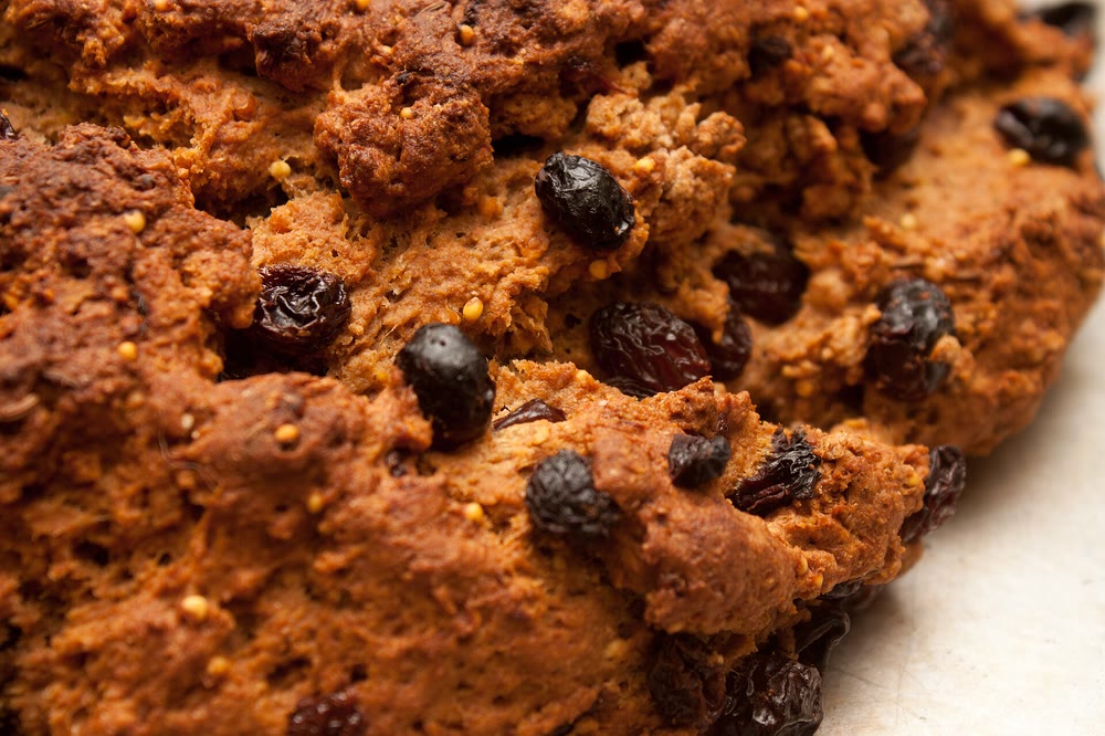 Close-up of the crusty top of a wholemeal soda bread studded with dark raisins