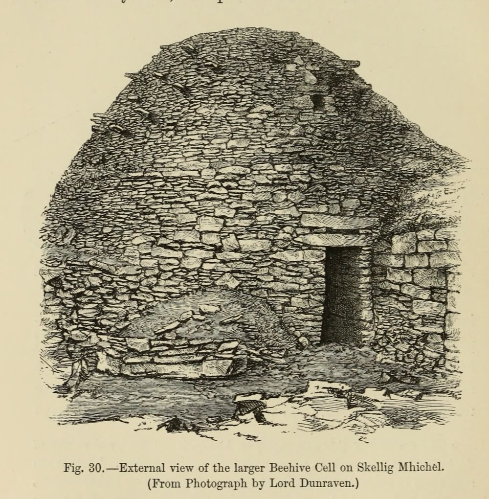 19th-century engraving of a large dry-stone beehive hut on Skellig Michael, with a dark rectangular doorway and rough corbelled walls rising to a rounded top